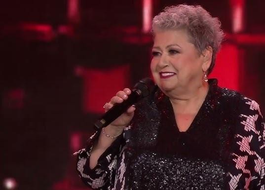 Ewa Bem podczas występu na żywo, z pasją wykonująca utwór muzyczny.