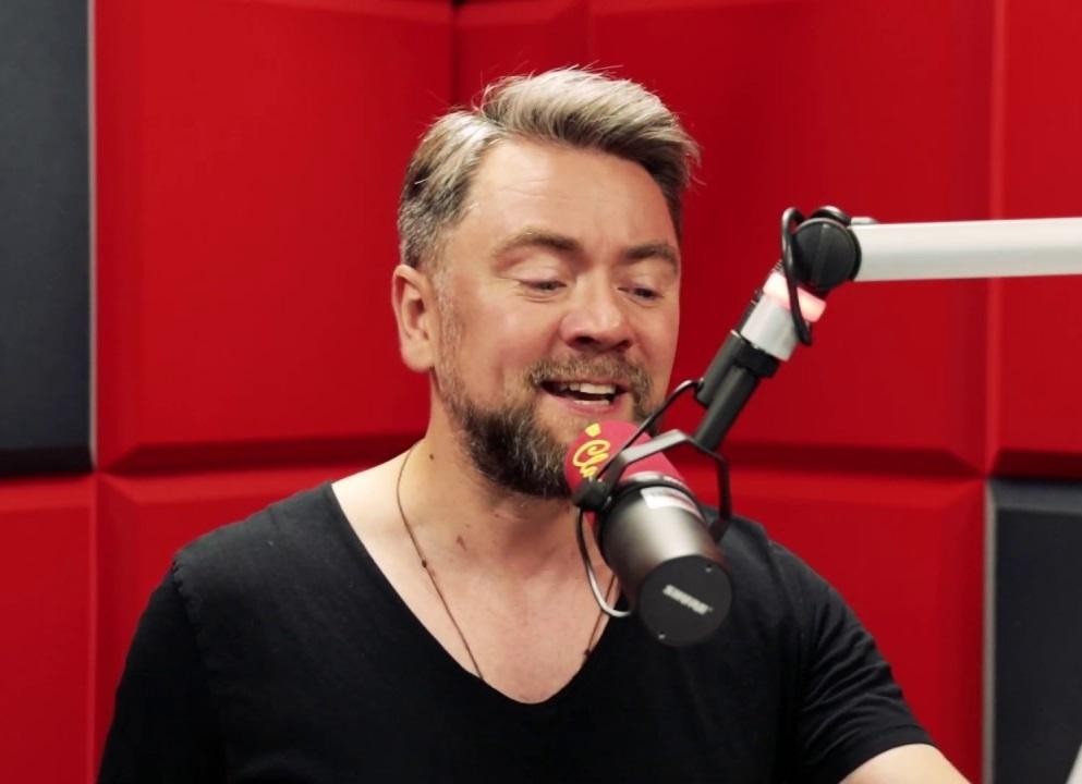 Kuba Badach w trakcie energetycznego występu wokalnego na scenie.