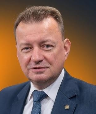 Mariusz Błaszczak podczas wykonywania obowiązków politycznych, sugerujące jego doświadczenie jako ministra obrony narodowej i spraw wewnętrznych.
