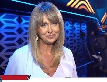 Ewa Wachowicz prezentuje sposób przygotowania dania w kuchni, uśmiecha się, skupiona na gotowaniu.