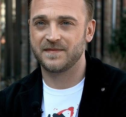 Mateusz Gessler w akcji w profesjonalnej kuchni podczas przygotowywania posiłku.