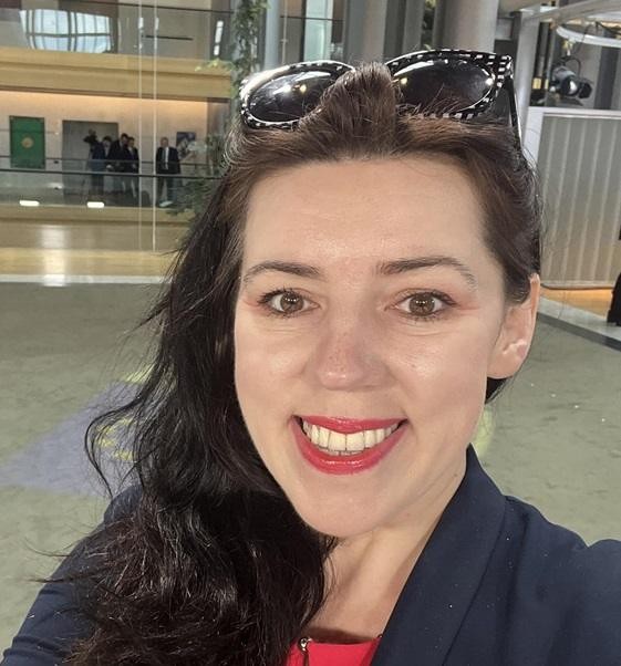 Dominika Ćosić, polska dziennikarka i pisarka, w swoim gabinecie, otoczona materiałami związanymi z polityką międzynarodową i literaturą.