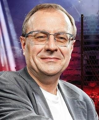Dłonie profesora Antoniego Dudka spoczywające na otwartej książce historycznej w jego gabinecie.