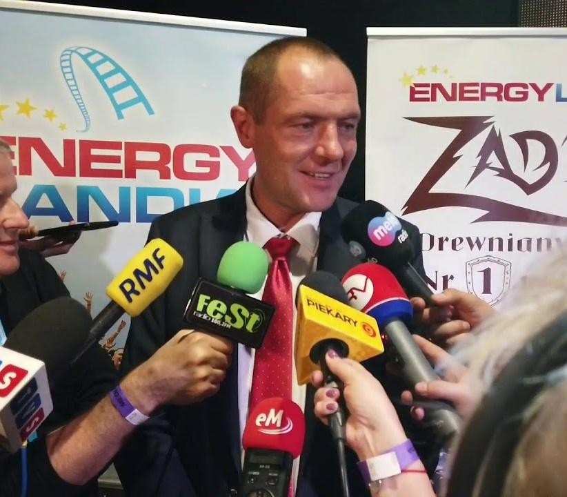 Energylandia – największy park rozrywki w Polsce, obok dynamicznego ujęcia rajdowego samochodu SSV na pustynnej trasie.